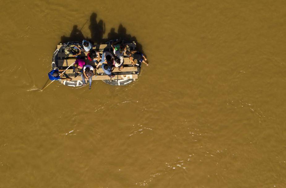 Migrantes usam um bote improvisado para atravessar o Rio Suchiate de Tecun Uman, na Guatemala, para Ciudad Hidalgo, no México, 6 de junho
