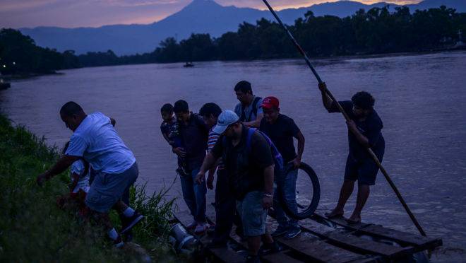 Imigrantes da América Central cruzam um rio no México, rumo aos Estados Unidos.