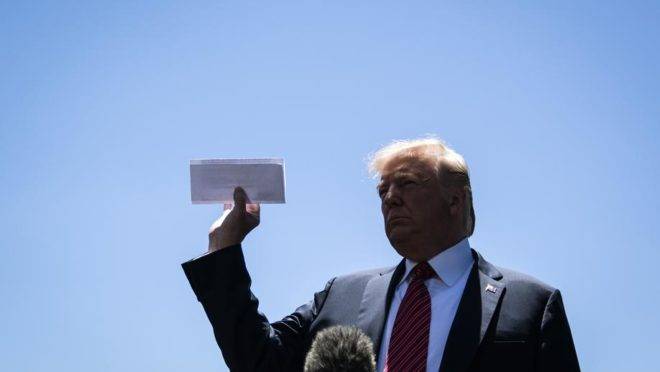 O presidente dos EUA Donald Trump mostra um documento que seria uma página do acordo ainda não revelado entre Estados Unidos e México em um jardim da Casa Branca, Washington, 11 de junho