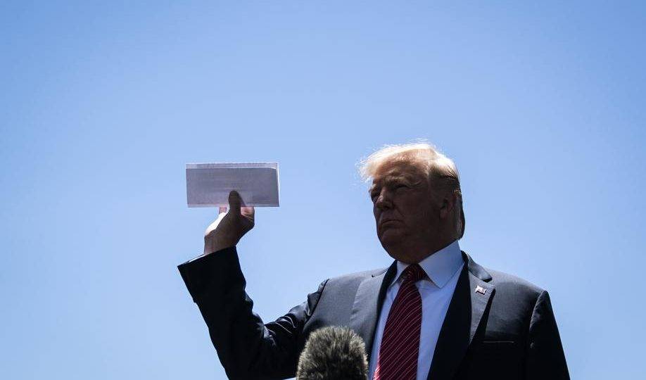 O presidente dos EUA Donald Trump mostra um documento que seria uma página do acordo ainda não revelado entre Estados Unidos e México em um jardim da Casa Branca, Washington, 11 de junho