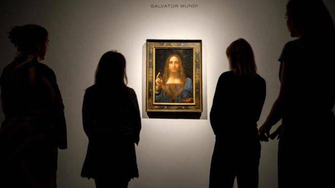 Nesta foto de 22 de outubro de 2017, funcionários da Christie's observam a pintura "Salvator Mundi", de Leonardo da Vinci, em Londres, antes de ser arrematada por US$ 450 milhões. O quadro estaria agora no iate do príncipe herdeiro da coroa saudita, Mohamed bin Salman