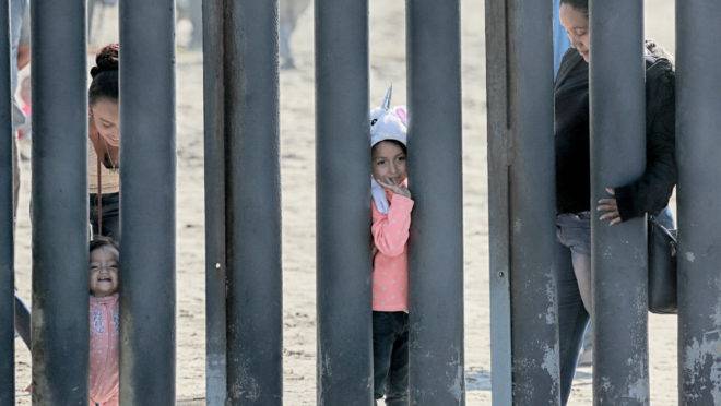 Imigrantes na fronteira do México com os EUA, em San Ysidro, Califórnia