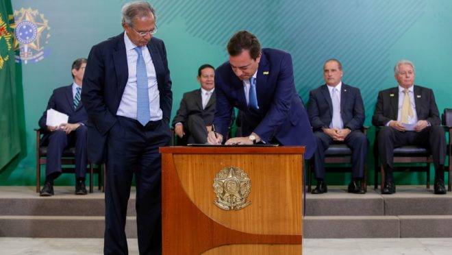 O ministro da Economia, Paulo Guedes, e o presidente da Caixa, Pedro Guimarães, em foto de janeiro de 2019: banco estatal vai devolver dinheiro que a União emprestou.