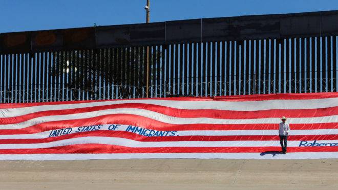 Faixa de protesto às políticas americanas de imigração, colocada no muro de fronteira com o México, perto do Rio Grande.