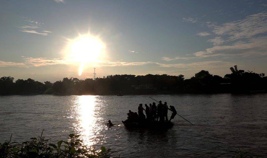 Migrantes e residentes usam um bote improvisado para atravessar ilegalmente o Rio Suchiate, de Tecum Uman, Guatemala, para Ciudad Hidalgo, México, em 14 de junho