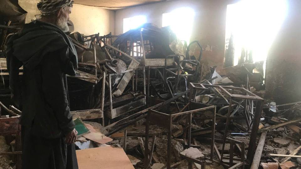 Um segurança olha carteiras danificadas e destroços no interior da escola para meninas Sher Ali Khan em Naw Deh, na província de Farah, Afeganistão, em abril de 2019. Dois ataques a bomba no Afeganistão renovaram os temores de uma volta da repressão caso o Talibã se torne parte de um governo futuro