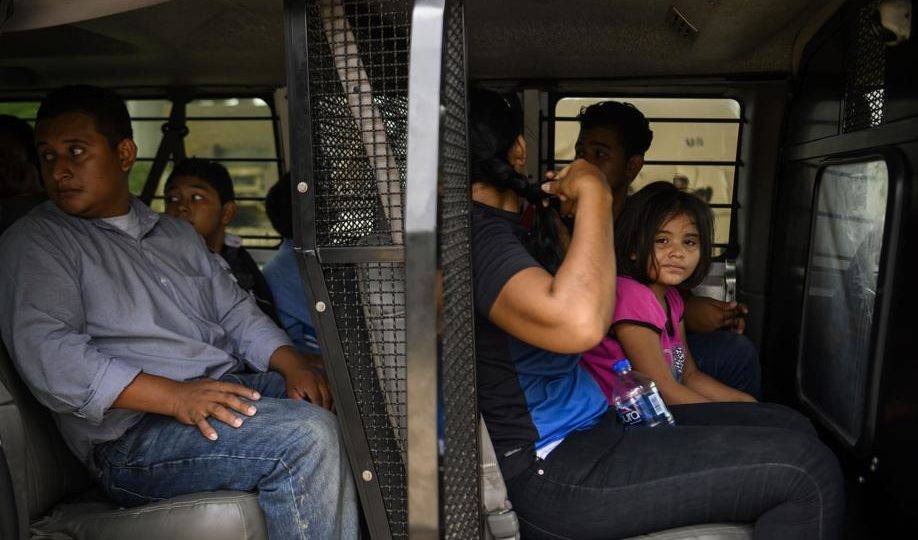 Famílias de migrantes entram em um veículo em uma área que a Patrulha da Fronteira usa para verificar a saúde a informações de identificação dos migrantes em McAllen, Texas, 21 de junho