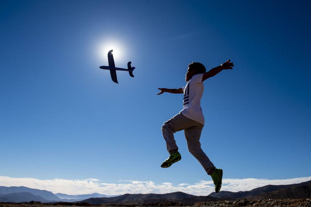 Menino brinca com avião de brinquedo pouco antes do eclipse solar, em La Higuera, no Deserto do Atacama, Chile. Um eclipse solar total foi visto em regiões do Chile e da Argentina na terça-feira, 2 de julho. Foto: Martin BERNETTI / AFP<br /> Menino brinca com avião de brinquedo pouco antes do eclipse solar, em La Higuera, no Deserto do Atacama, Chile. Um eclipse solar total foi visto em regiões do Chile e da Argentina na terça-feira, 2 de julho. Foto: Martin BERNETTI / AFP<br />
