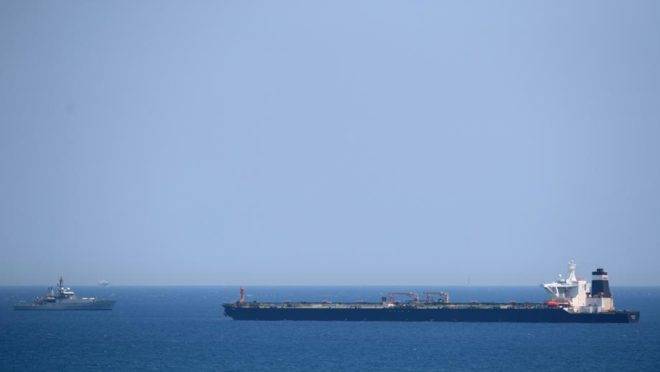 Um navio da Marinha Real Britânica (à esquerda) em patrulha perto do supertanque Grace 1, suspeito de transportar petróleo cru para a Síria, violando sanções da UE, após ter sido detido na costa de Gibraltar, 4 de julho
