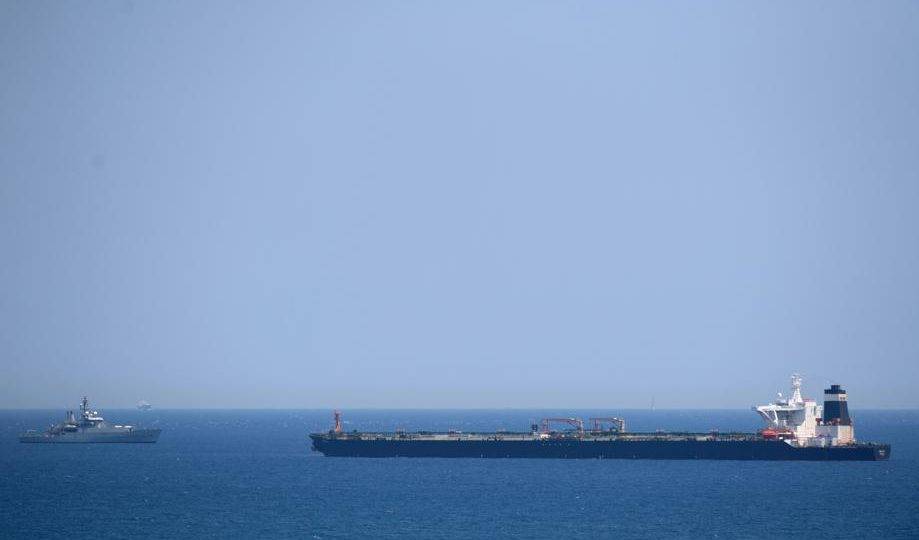 Um navio da Marinha Real Britânica (à esquerda) em patrulha perto do supertanque Grace 1, suspeito de transportar petróleo cru para a Síria, violando sanções da UE, após ter sido detido na costa de Gibraltar, 4 de julho