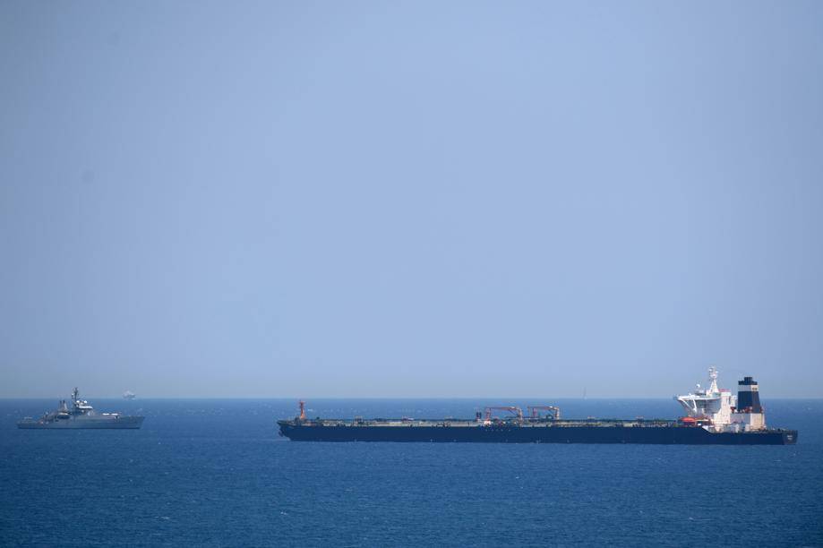 Um navio da Marinha Real Britânica (à esquerda) em patrulha perto do supertanque Grace 1, suspeito de transportar petróleo cru para a Síria, violando sanções da UE, após ter sido detido na costa de Gibraltar, 4 de julho