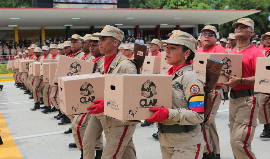 Membros da milícia venezuelana seguram caixas dos Comitês Locais de Abastecimento e Produção (CLAP) ao desfilar diante de Nicolás Maduro durante parada militar no dia da Independência da Venezuela, em Caracas, 5 de julho
