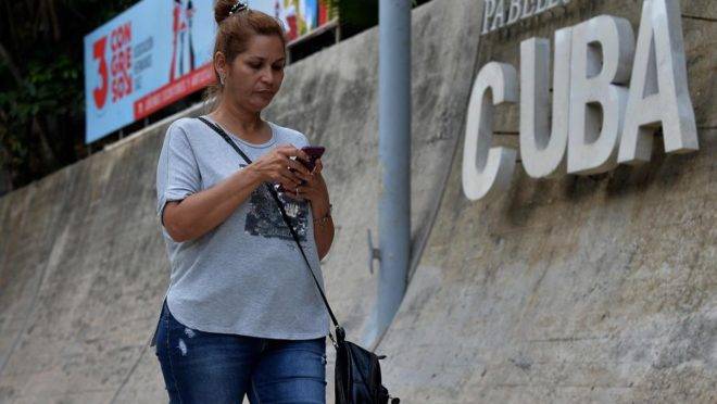 Mulher usa telefone celular para se conectar à internet em Havana, em dezembro de 2018, quando a internet móvel começou a funcionar no país