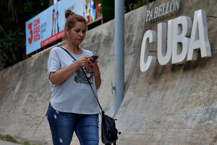 Mulher usa telefone celular para se conectar à internet em Havana, em dezembro de 2018, quando a internet móvel começou a funcionar no país