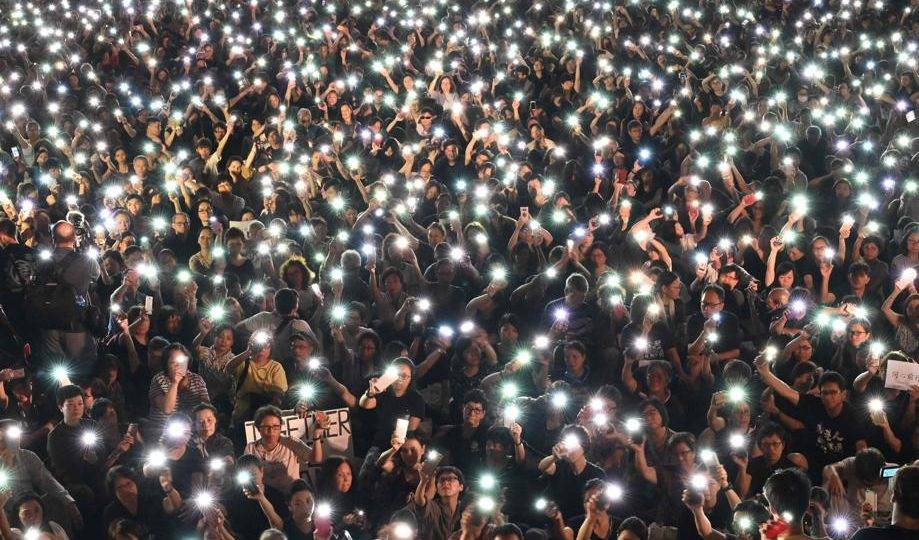 China expande seus veículos de comunicação no exterior – e não apenas em chinês Manifestantes seguram celulares durante marcha organizada por mães de Hong Kong em apoio aos manifestantes que protestam contra o projeto de lei que permitiria a extradição para a China