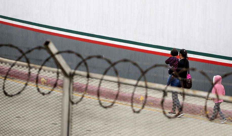 EUA enviarão mais soldados para a fronteira com o México Uma migrante centro-americana e seus filhos em frente ao ponto de entrada em El Chaparral, em Tijuana, no estado mexicano de Baja California, em 17 de julho de 2019