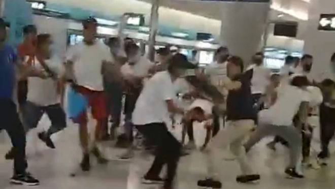 Homens vestindo camisetas brancas entram em confronto com manifestantes pró-democracia na estação Yuen Long em Hong Kong.