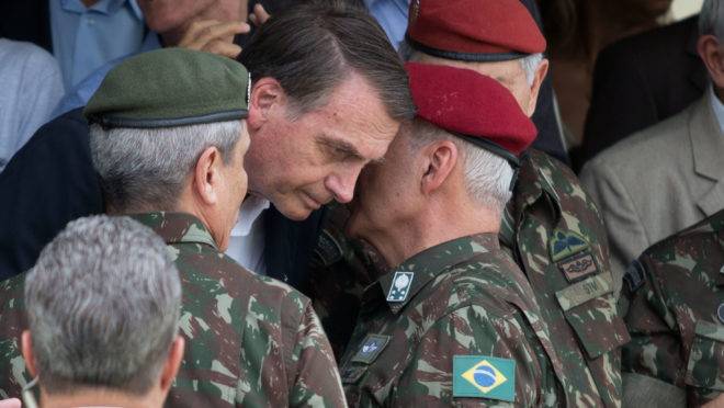Militares falam ao ouvido de Bolsonaro.