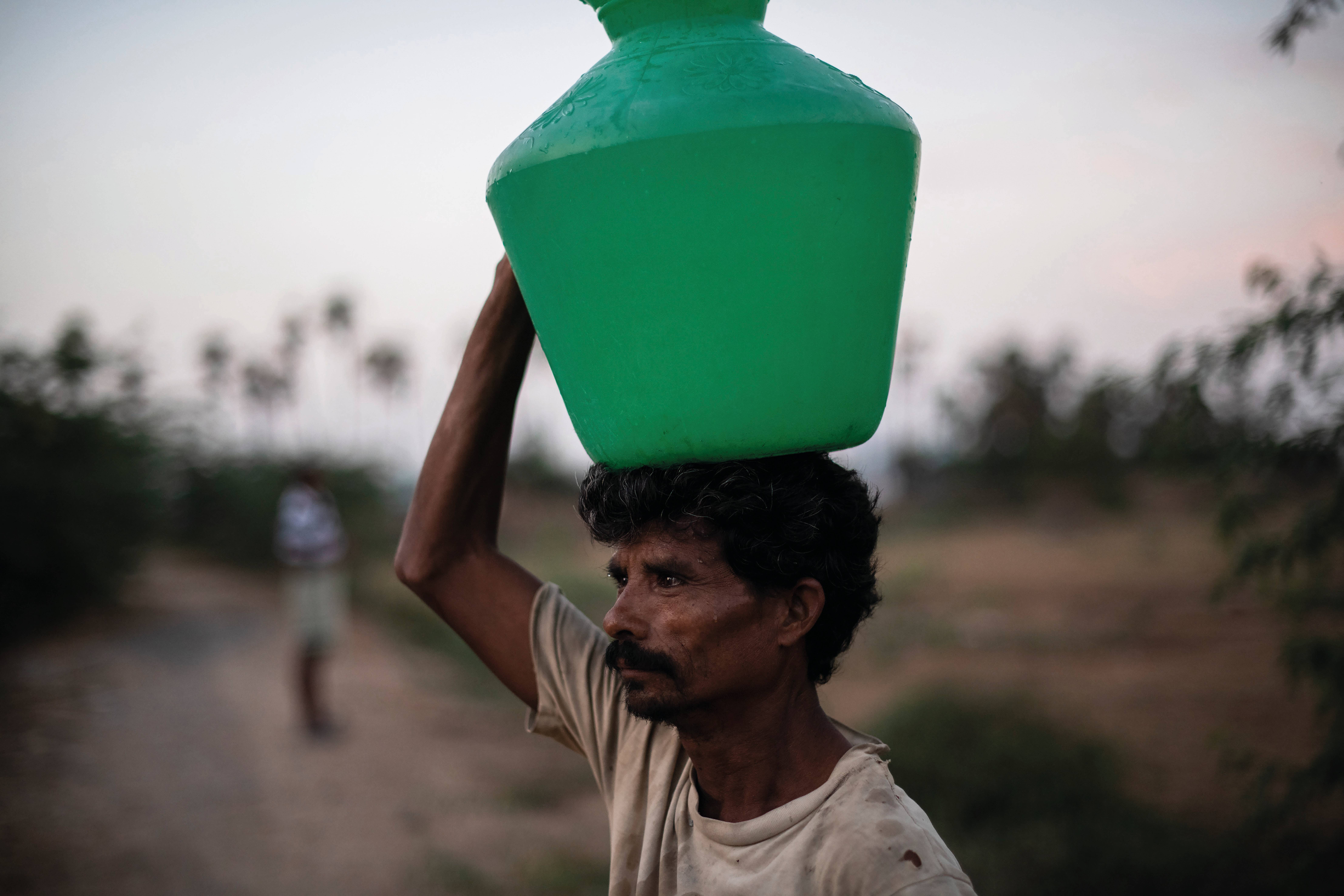 Trabalhador coleta água em Chennai, Índia