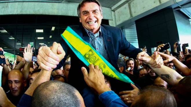 Jair Bolsonaro é carregado por apoiadores no Aeroporto Afonso Pena, em Curitiba, em março de 2018.