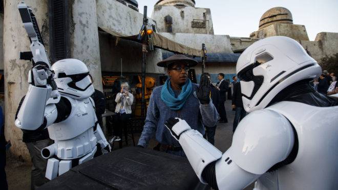 Atores em roupas de tropa interestelar interagem com frequentador do parque Star Wars, em Anaheim, Califórnia.
