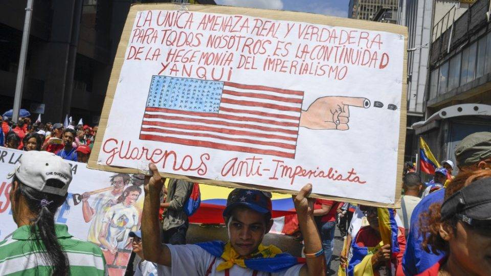 Manifestante pró-Maduro segura cartaz com mensagem contra os Estados Unidos em protesto contra as sanções americanas em Caracas, 7 de agosto de 2019