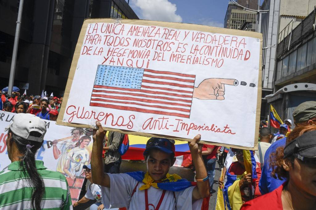 Manifestante pró-Maduro segura cartaz com mensagem contra os Estados Unidos em protesto contra as sanções americanas em Caracas, 7 de agosto de 2019