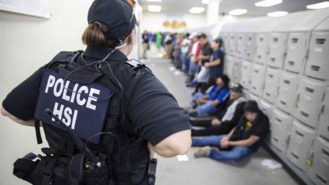 Agente do departamento de Investigações de Segurança Interna vigia suspeitos imigrantes ilegais em 7 de agosto de 2019. Agentes detiveram cerca de 680 imigrantes que trabalhavam em sete fábricas em cidades do Mississippi supostamente de maneira ilegal