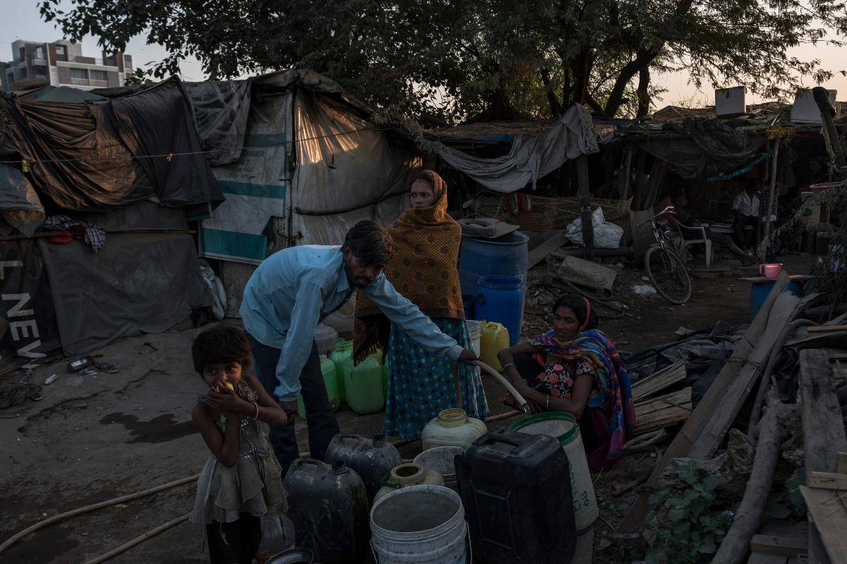 Moradores coletam água do lado de fora de uma barraca de chá em Ahmedabad, estado de Gujarat, Índia, em 24 de novembro de 2018 | REBECCA CONWAY/NYT