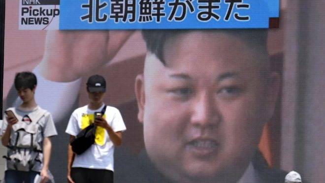 Pedestre passam por uma tela em Tóquio que noticia o lançamento de mísseis pela Coreia do Norte no dia 10 de agosto de 2019