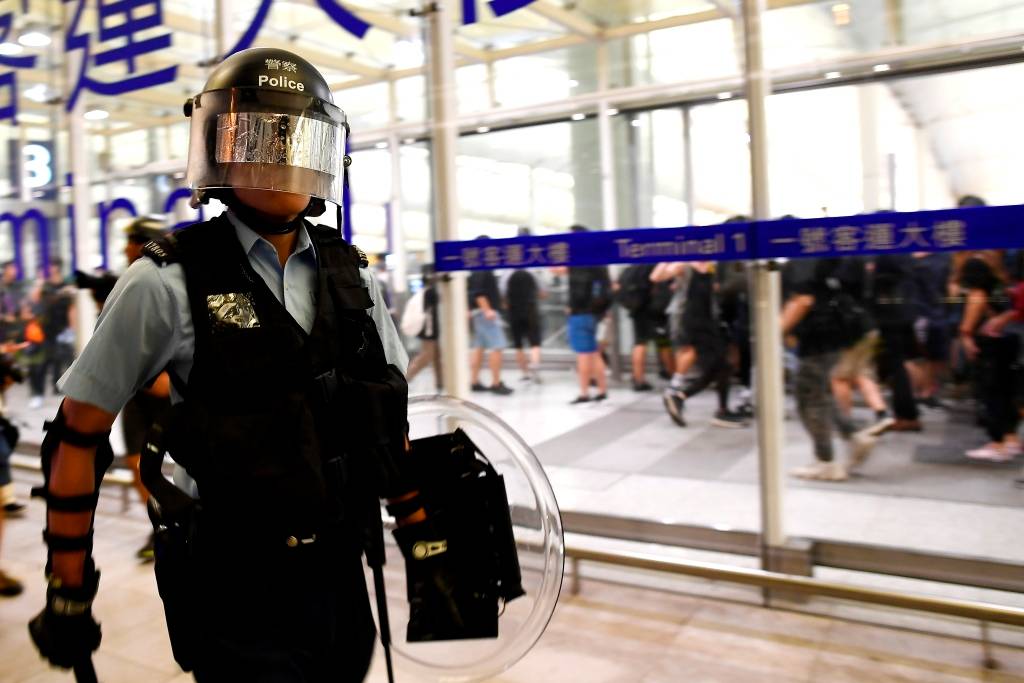 Policial faz segurança do aeroporto de Hong Kong após confronto com manifestantes
