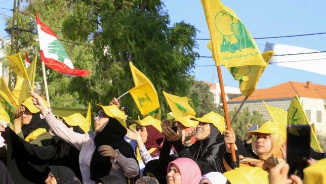 Mulheres apoiadoras do movimento militante xiita libanês Hezbollah agitam bandeiras do grupo em uma comemoração aos 13 anos do fim da guerra com Israel em 2006, na cidade do sul do Líbano Bint Jbeil, 16 de agosto de 2019