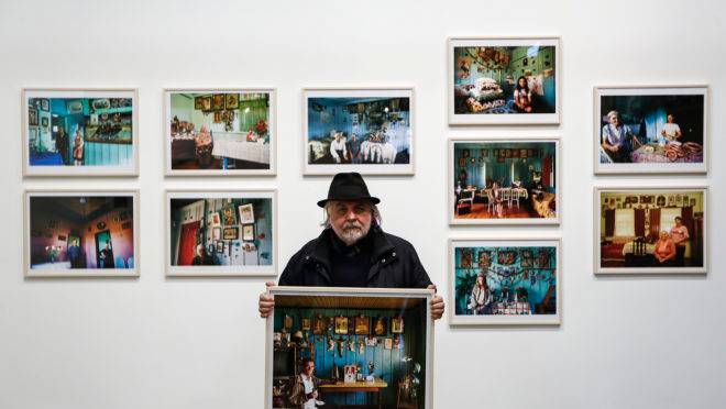 João Urban com algumas das imagens feitas ao logo de quatro décadas e que estão em exibição no Museu Paranaense.