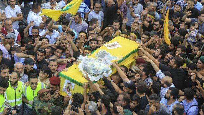 Members of Lebanon’s Shiite Hezbollah movement carry the coffin of the fellow comrade, who was killed in Israeli strikes in Syria, during the funeral in the Ghobeiry neighbourhood of southern Beirut on August 26, 2019. – The head of Hezbollah Hassan Nasrallah said on August 25 that Israeli strikes overnight in Syria had hit a position used by his Lebanese Shiite group, killing two of its members. (Photo by – / AFP)