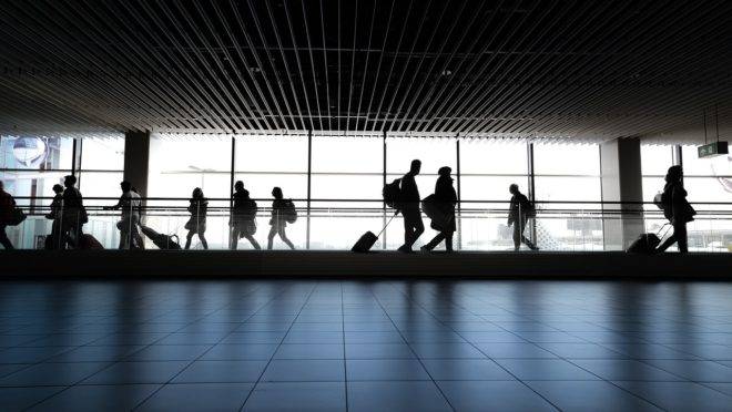 Passageiros transportando bagagens em aeroporto