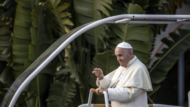 Papa Francisco acena de dentro do papamóvel.