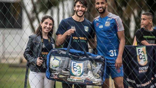 Manuella Carvalho e André Georges, da Football for a Cause, e o lateral Jorge, do Santos