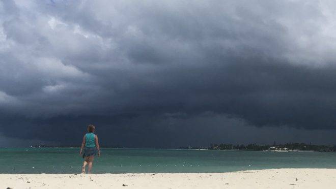 Mulher caminha pela praia enquanto uma tempestade se aproxima de Nassau, nas Bahamas, 12 de setembro de 2019