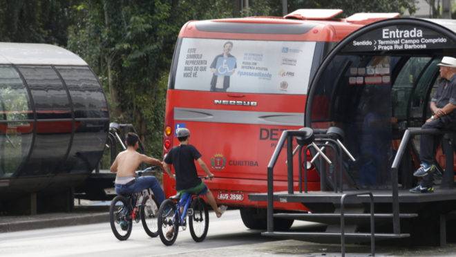 Cena comum na canaleta do biarticulado de Curitiba: jovens pegando rabeira no ônibus.