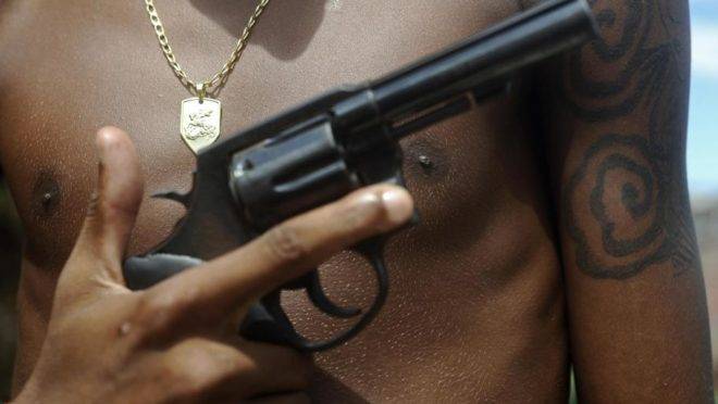 homem empunha arma de fogo