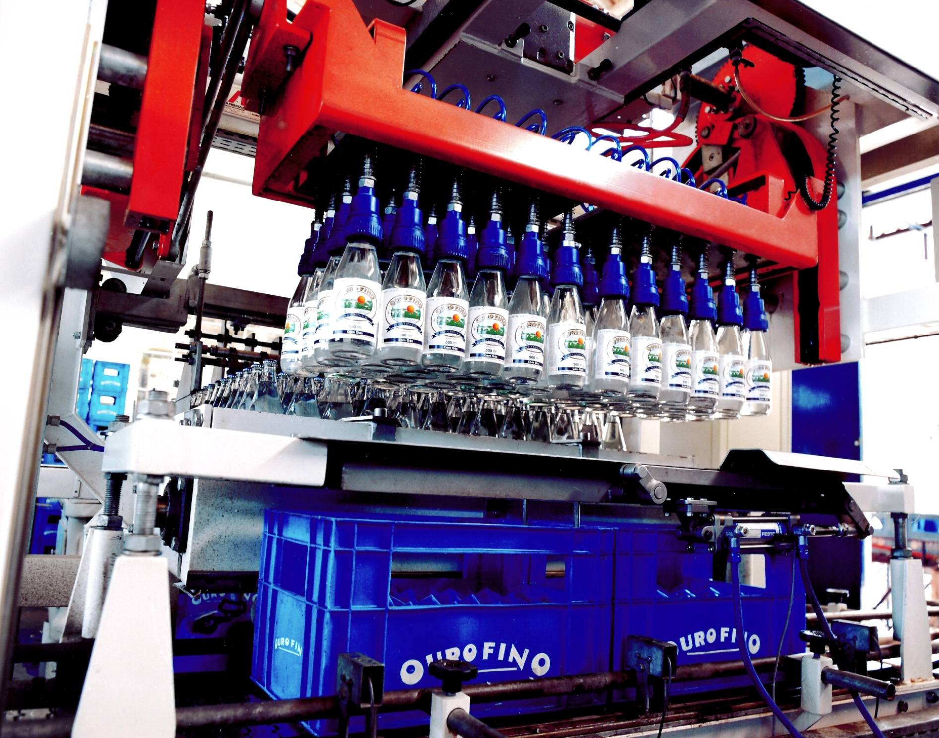 Garrafas de água ouro fino sendo envasadas automaticamente, na linha de produção.