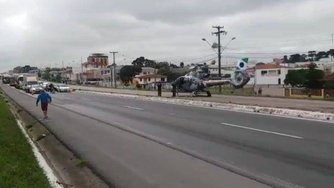 Helicóptero pousado em rodovia para socorrer vítima atropelada