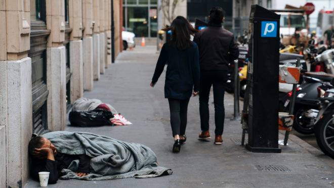 Pedestres passam por moradores de rua em San Francisco.