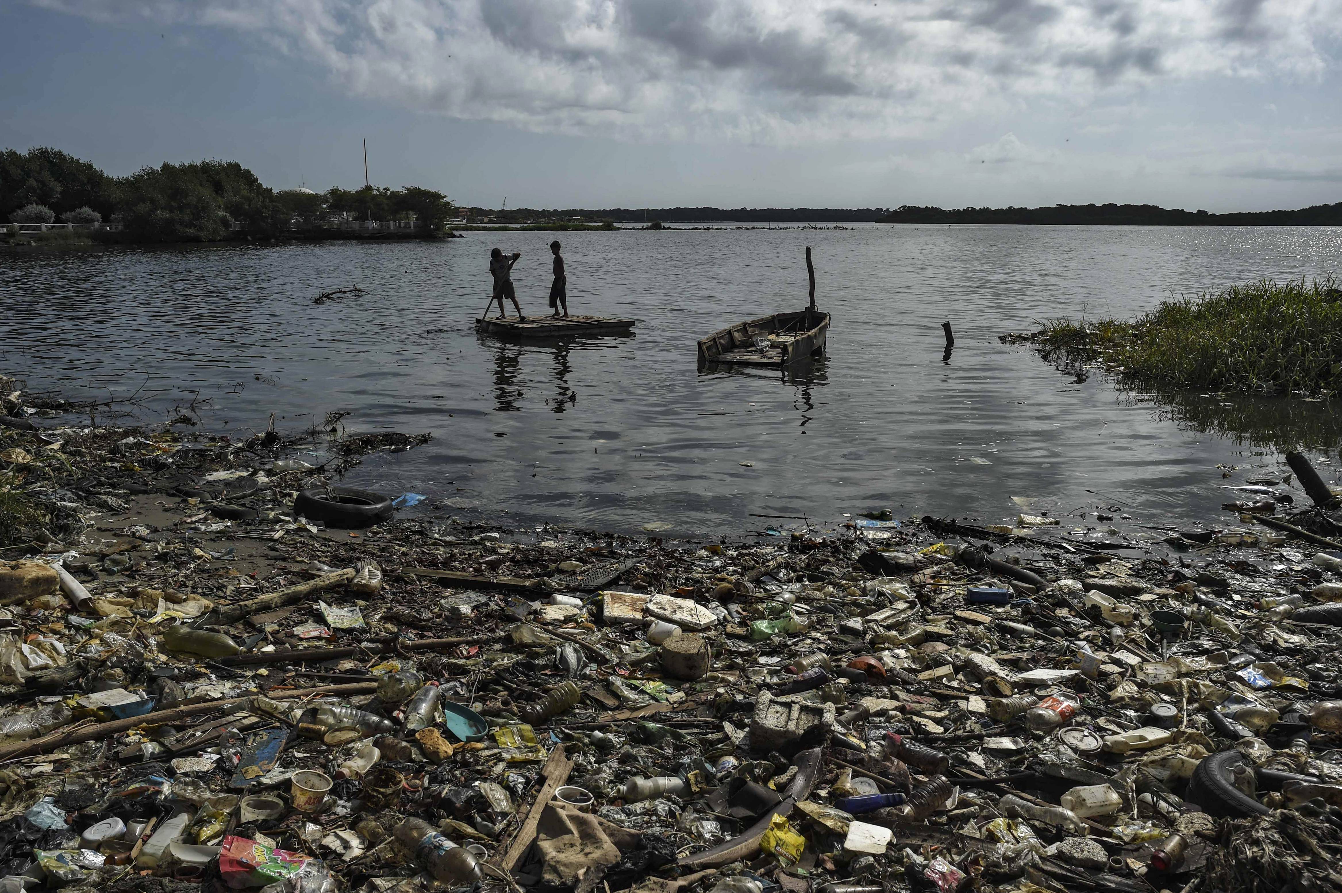 Crianças navegam em uma pequena balsa nas águas poluídas do lago Maracaibo | Foto: YURI CORTEZ / AFP Crianças navegam em uma pequena balsa nas águas poluídas do lago Maracaibo | Foto: YURI CORTEZ / AFP