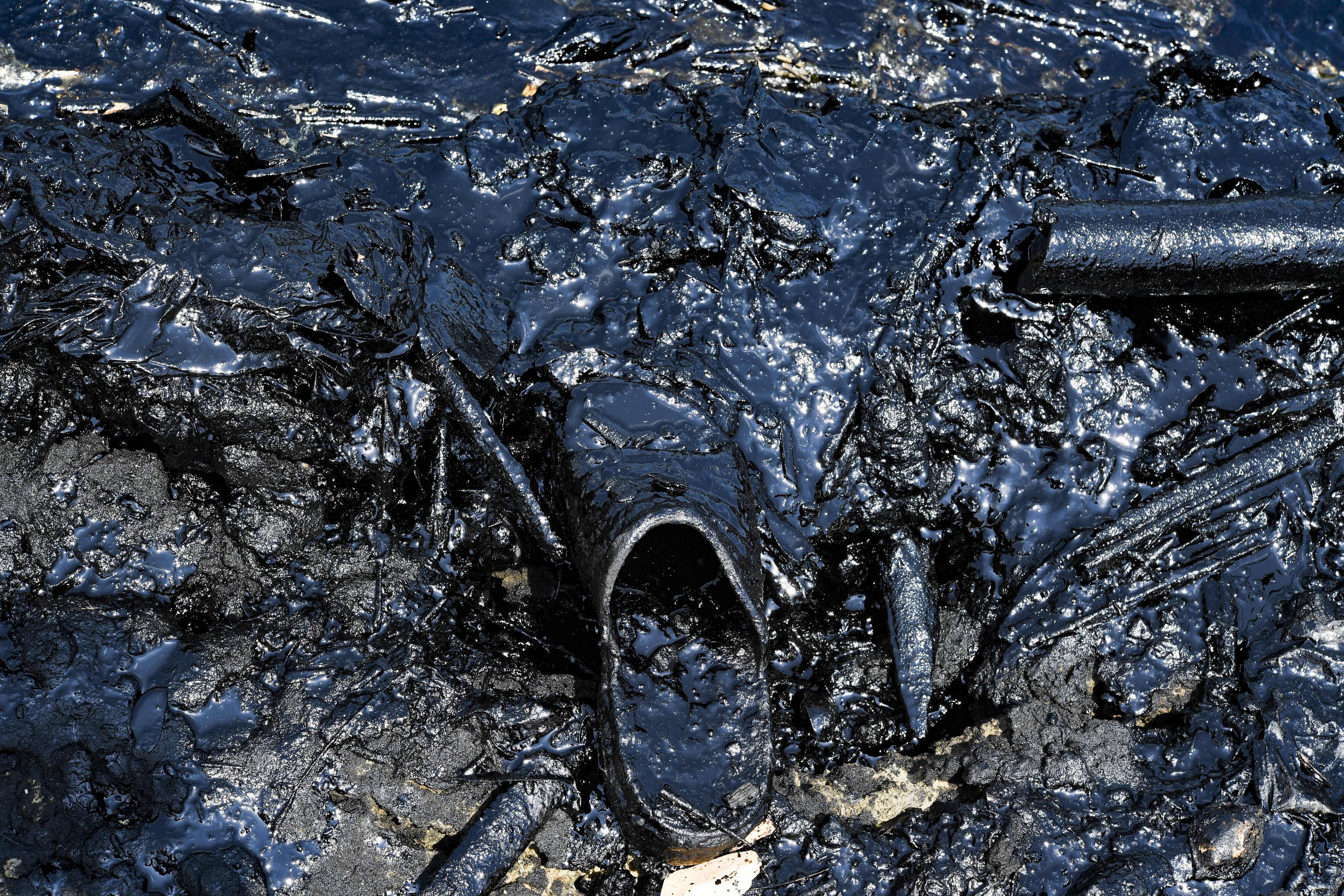 Sandália manchada de óleo após um derramamento nas margens do poluído Lago Maracaibo | Foto: YURI CORTEZ/AFP Sandália manchada de óleo após um derramamento nas margens do poluído Lago Maracaibo | Foto: YURI CORTEZ/AFP
