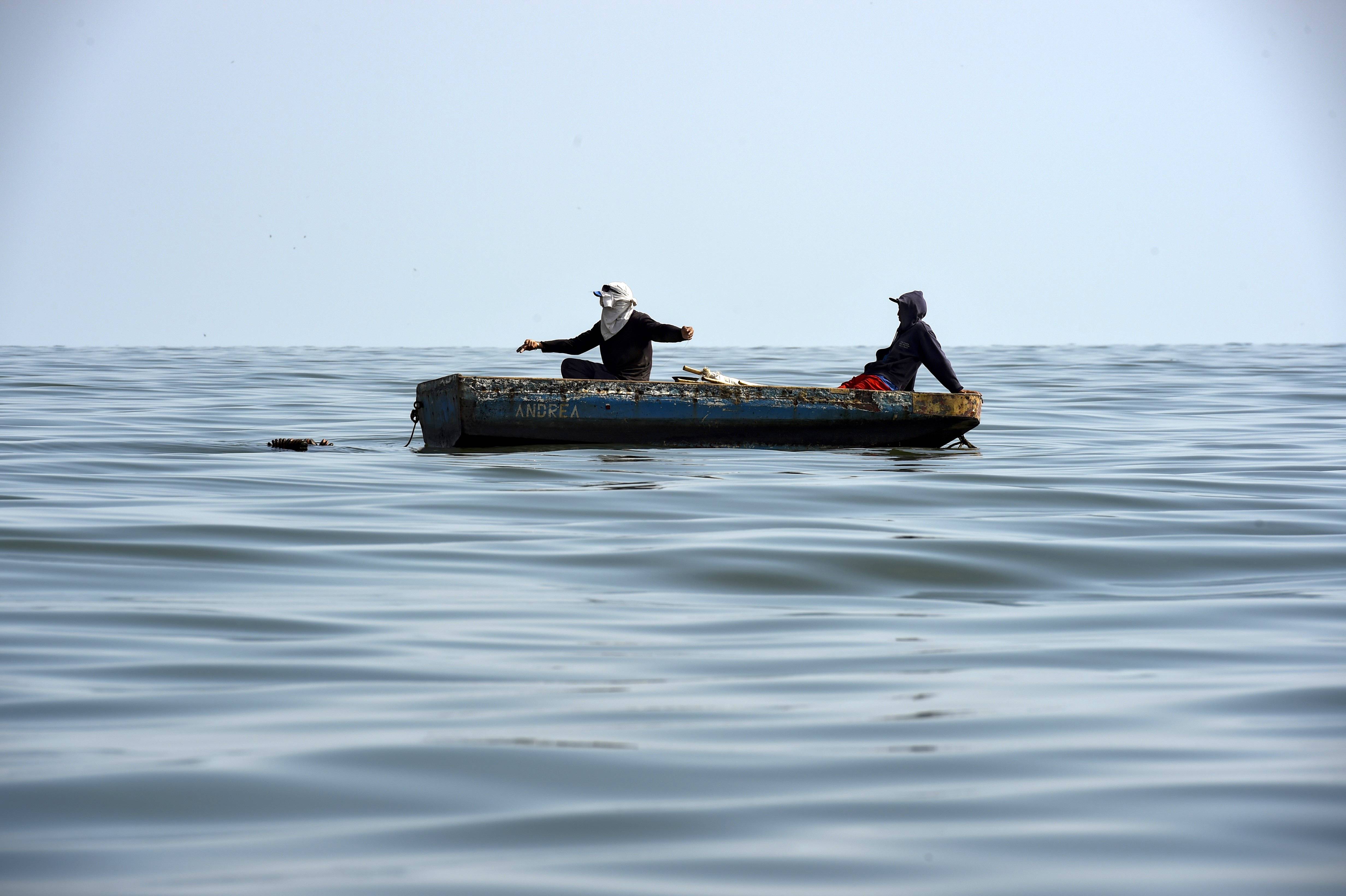 Moradores pescam nas águas poluídas do lago Maracaibo | Foto: YURI CORTEZ / AFP Moradores pescam nas águas poluídas do lago Maracaibo | Foto: YURI CORTEZ / AFP