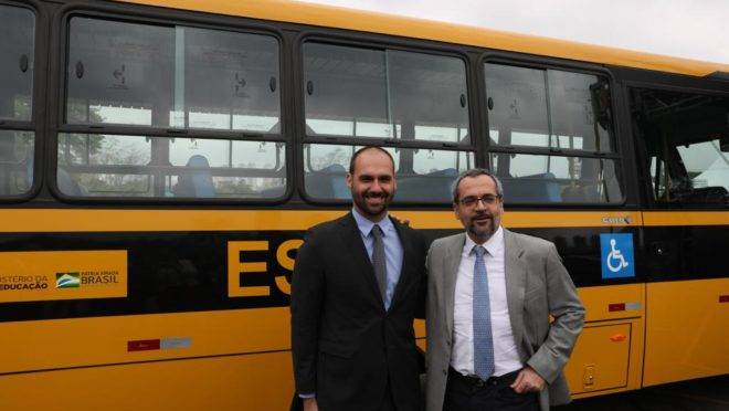 Ao lado de Eduardo Bolsonaro, ministro Abraham Weintraub entrega ônibus escolares comprados no governo anterior.