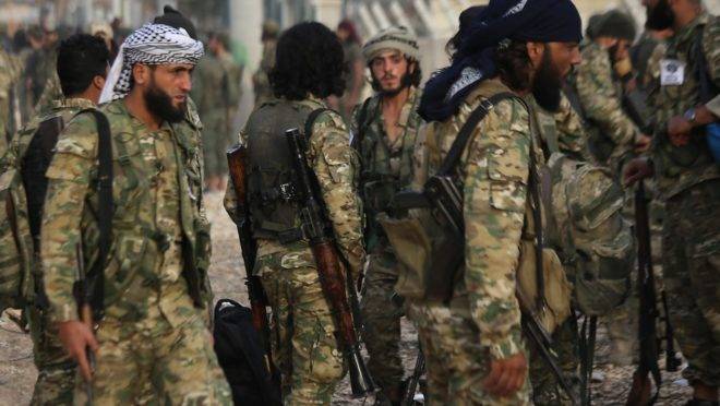Combatentes sírios apoiados pela Turquia se reúnem na vila de Akcakale, na Turquia, na fronteira com a Síria, 11 de outubro de 2019