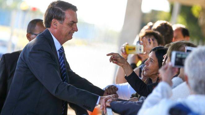 Bolsonaro, cumprimenta populares no portão do Palácio da Alvorada: