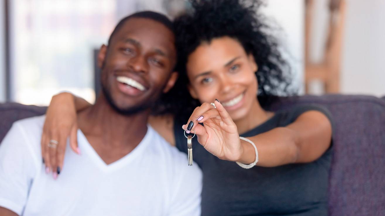 Casal feliz com as chaves da casa própria